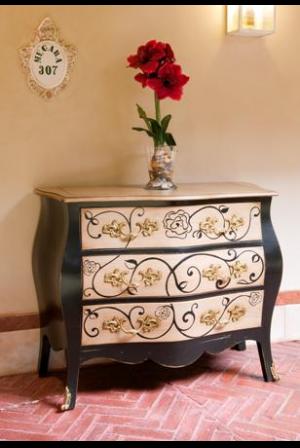 Cómoda en madera de cerezo. Con tres grandes cajones, pintada a mano y con doble tirador dorado.